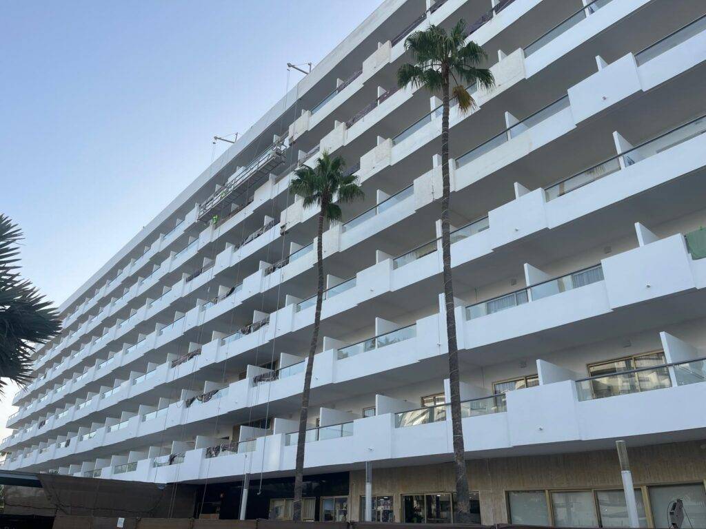 Fachada de balcones con plataforma suspendida en plena obra